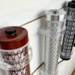 Close-up of decorative short tubular lights with patterned metal mesh and colored end caps