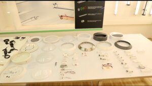 LED ceiling light components display table with diffusers, housings, drivers, and sensor modules arranged