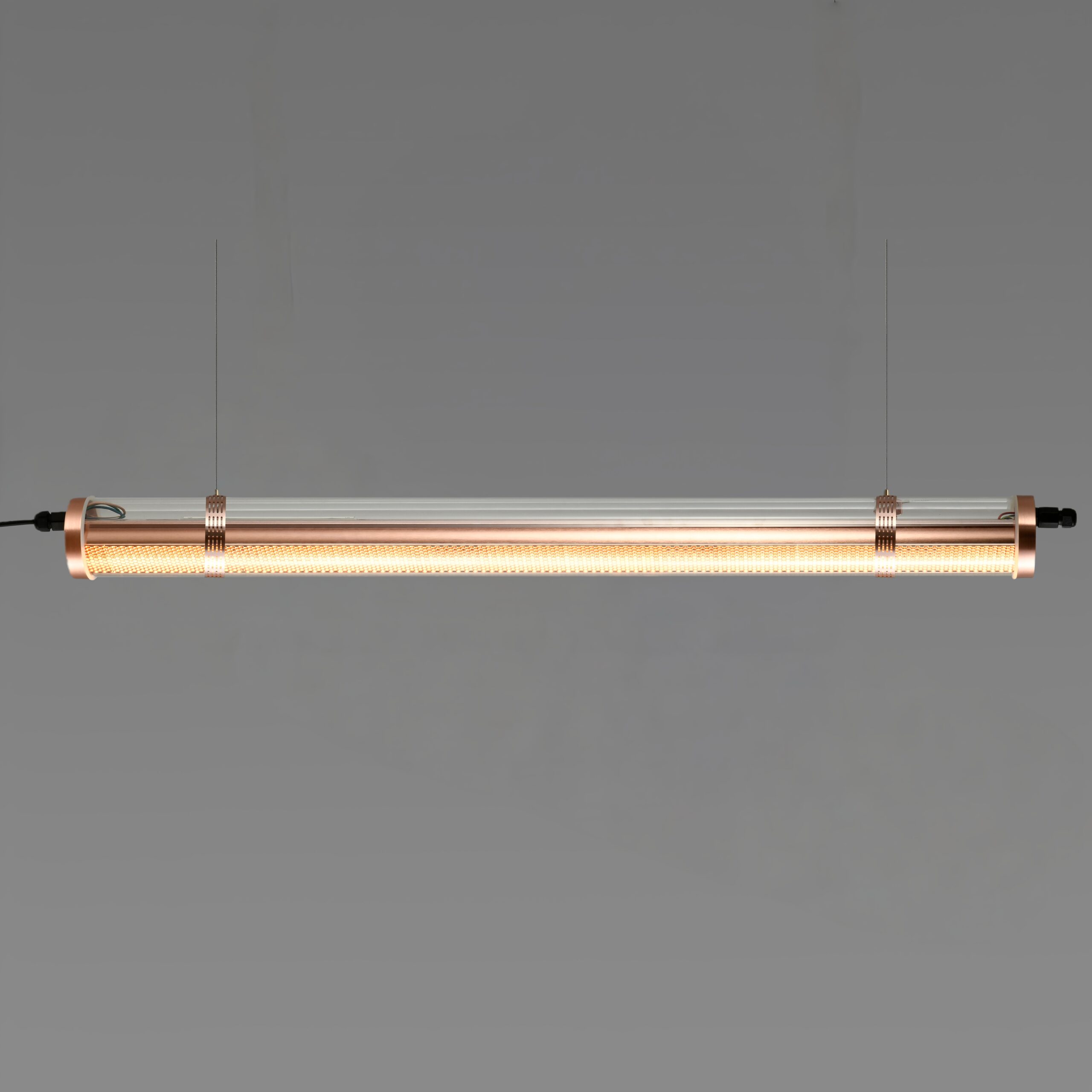 Titan architectural tubular luminaire with integrated honeycomb optic, suspended installation, warm brass-toned metal finish
