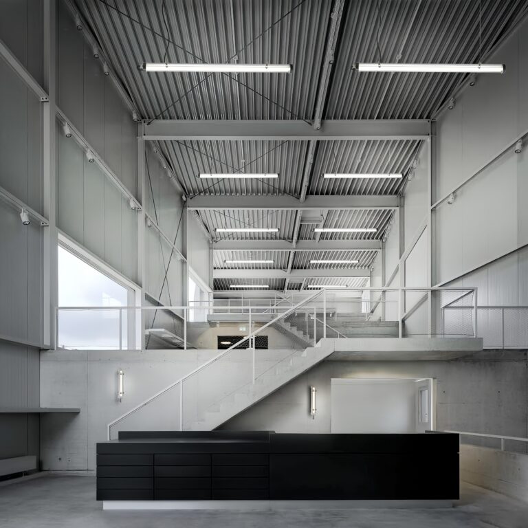 Wall-mounted and suspended installation tubular luminaires installed on a residential building façade, demonstrating clean, project-ready outdoor lighting application