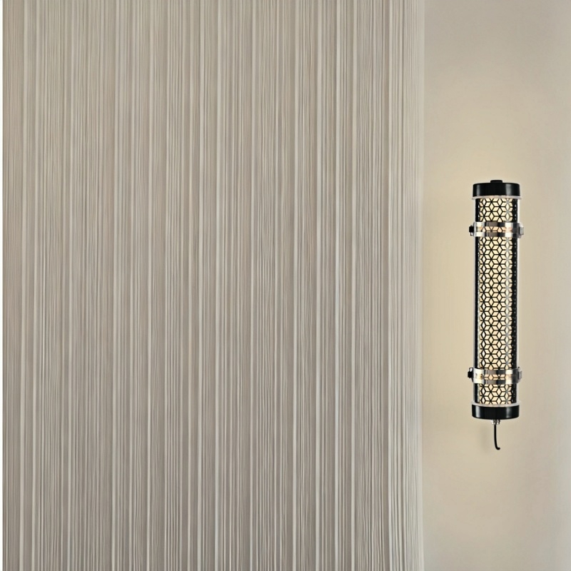Architectural tubular wall luminaire with metal grille integrated into minimal interior space