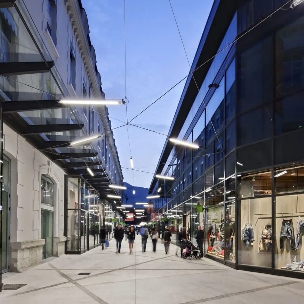 Tubular LED lights installed in an outdoor retail shopping mall walkway for storefront visibility and customer circulation lighting
