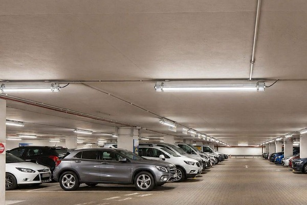 A well-lit underground parking garage with linear LED tri-proof lights
